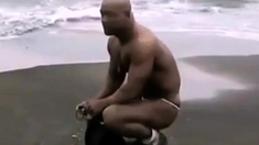 Asian bodybuilder barely covered at the beach